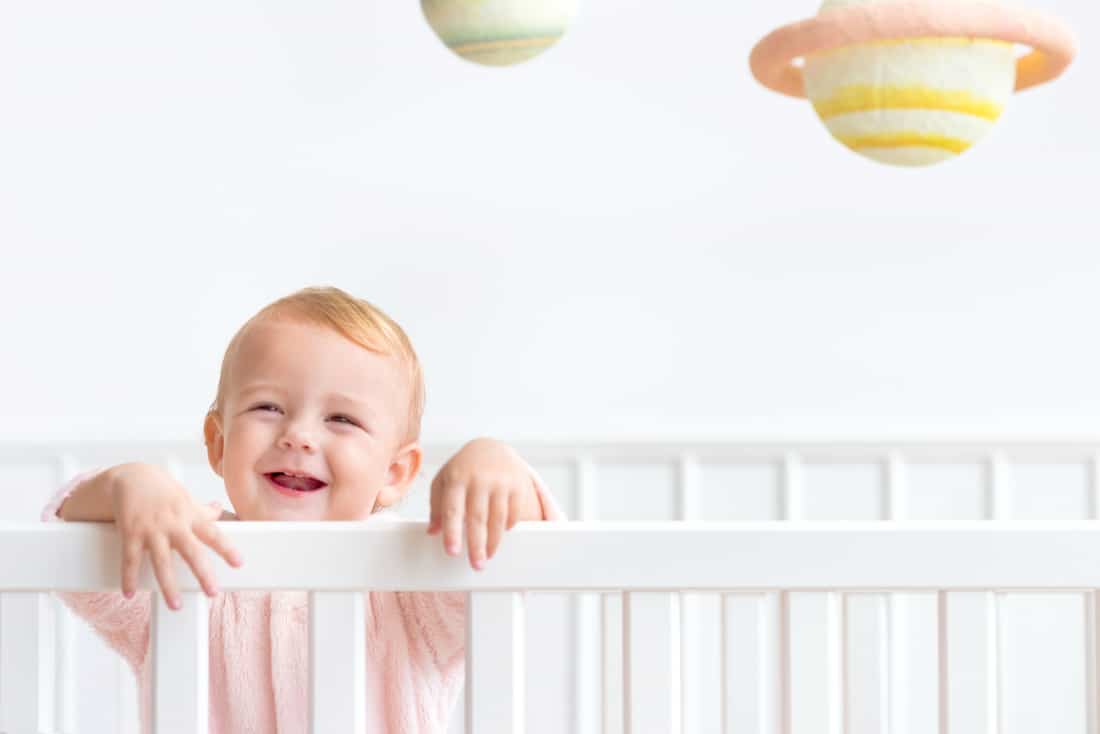 Baby staat in bed